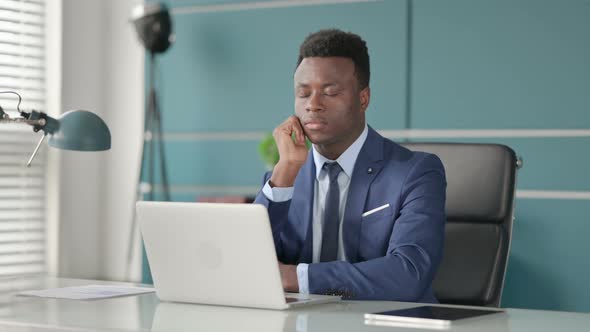 Tired African Businessman Taking Nap While Sitting in Office with Laptop