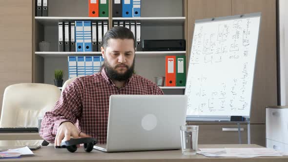 Man Comes To the Office, Puts the Headphones on His Ears and Starts Talking To a Customer