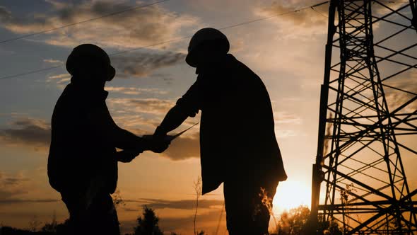 Engineers Shaking Hands at the Construction of Highvoltage Power