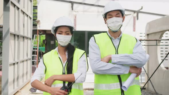 Asian construction workers people wearing protective face mask onsite of architecture due to Covid.