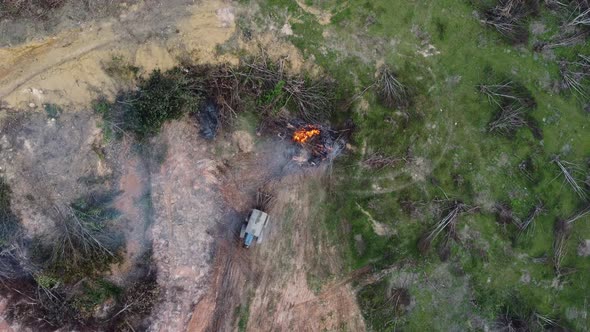 Top down view tractor push the bare tree to open fire