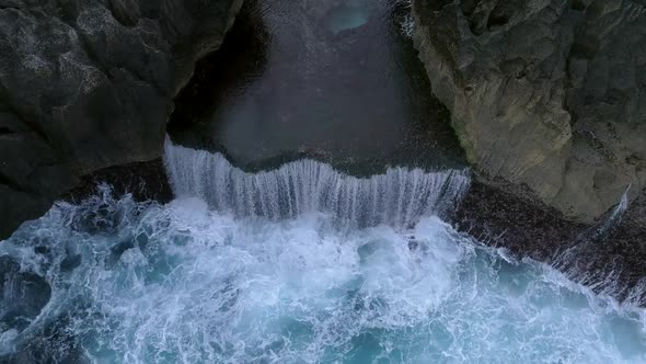 Aerial view of agitated water hitting rock formation, Bali island, Indonesia.