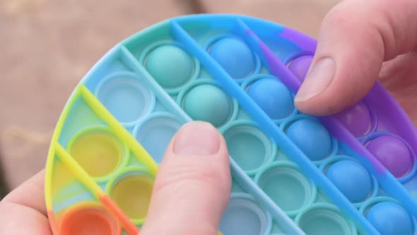 Closeup Shot of a Person Using a Colourful Pop It Toy