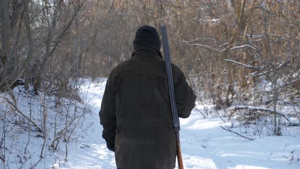 Hunting Hunter Men with Gun Walking Through the Forest During the Hunting Season.