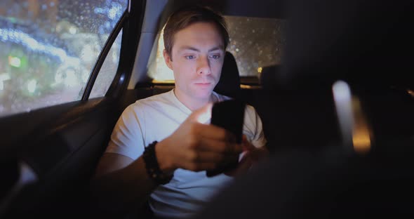 Man Chewing Gum in a Car Using Phone