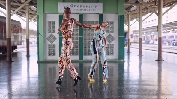 Fashion Models Dancing And Laughing In Train Station