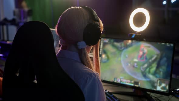 Back Shot of a Young Concentrated Teenage Girl Looking at a Computer Screen Playing a Esport Cyber