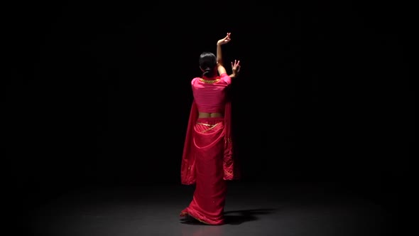 Back View Belly Dance of Young Woman in Shiny Red Dress, on Black Background, Slow Motion.