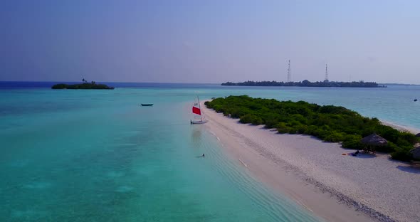 Daytime above island view of a sandy white paradise beach and turquoise sea background 