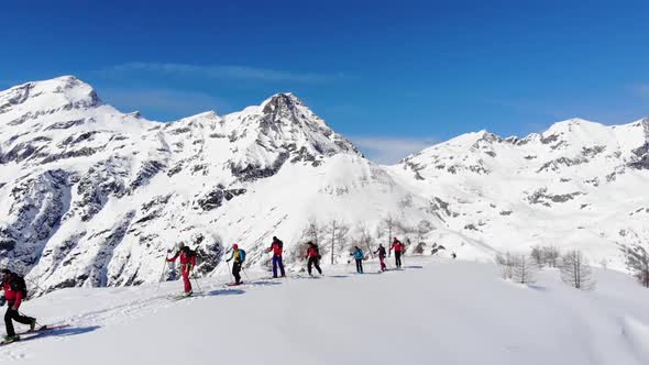 Group of ski touring on skin uphill in a line. Ski touring in big mountains