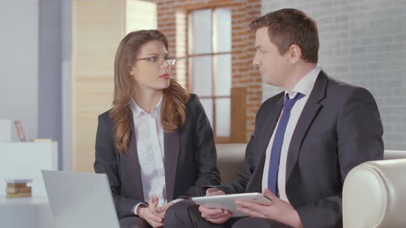 Male and Female Business Partners Completing Deal, Shaking Hands