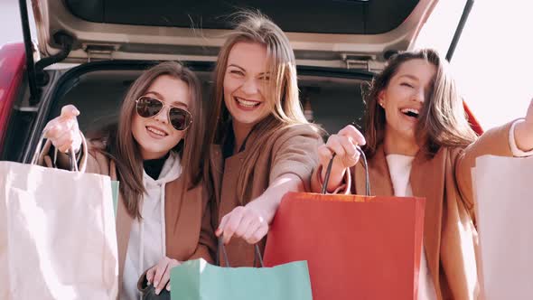 Attractive Girls Have Shopped and Checking Purchases at the Car Back