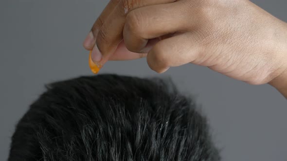 Men Applying Capsule Oil on Hair