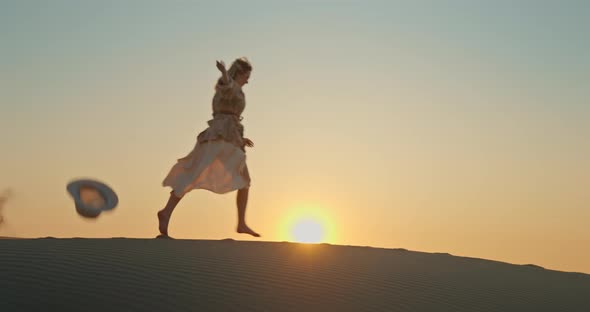 Woman Running By Sand Dune with Golden Sunset on Background. Inspirational 