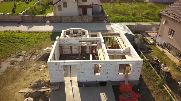 Aerial view of unfinished house walls under construction at building site.