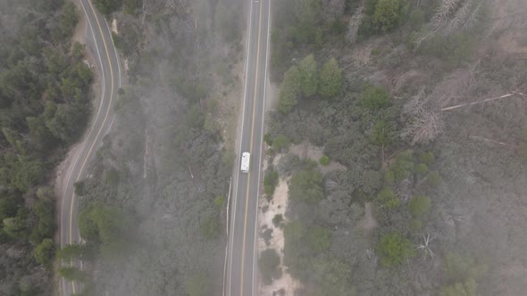 Aerial Top Down View Above Mountain Serpentine Road with White RV Vehicle Bus