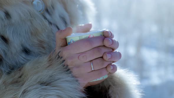 The Girl Is Drinking Coffee in the Winter Morning Outside