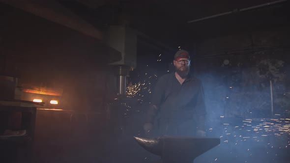 Tall Bearded Blacksmith at Workplace