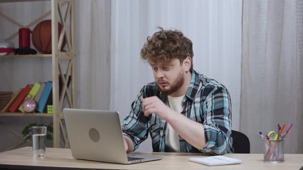 Young Tired Man in Checkered Shirt Typing on Laptop Keyboard Then Closes It and Falls Asleep