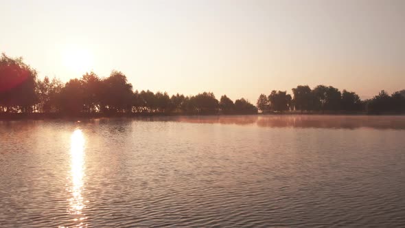 Sun Reflection in Lake with Morning Mist at Sunrise