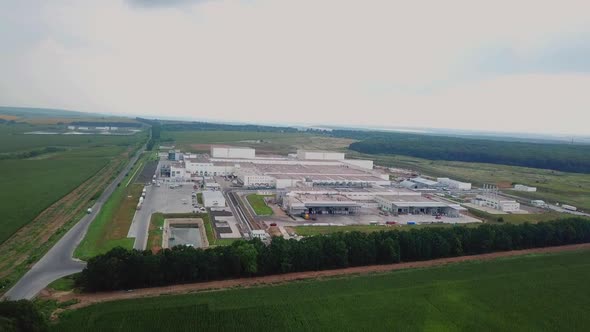 Aerial view of a factory or industrial area surrounded by green fields. Manufacturing plant.