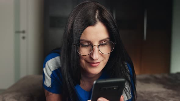 Closeup Female Looking Photo in Social Networks Holding Telephone