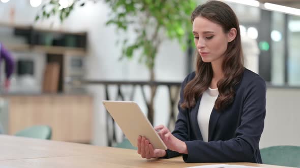 Young Businesswoman Using Digital Tablet at Work