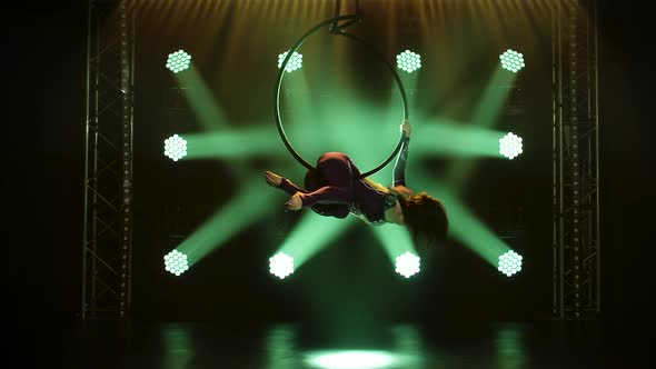 Young Woman Doing Show Acrobatic Trick on Aerial Hoop, Exciting Acrobatic Show in a Dark Studio with