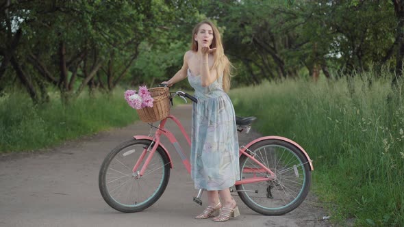 Positive Young Caucasian Woman Sending Air Kiss at Camera and Smiling. Wide Shot of Charming