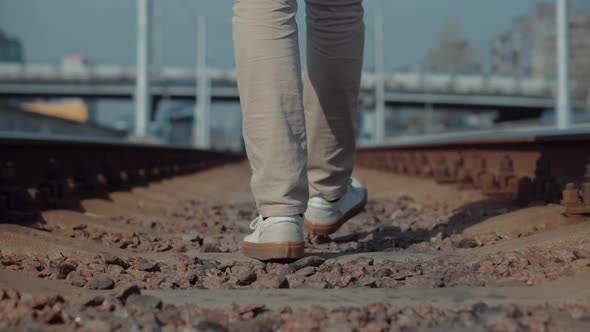 Walks On Railroad Tracks.Legs Walking On Railway Middle Of Rail.Feet In Pants Walking On Rail Road