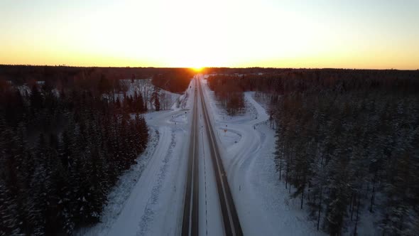 Drone over winter highway at sunset, Sweden