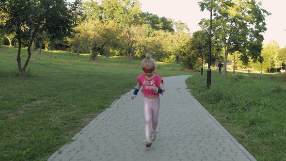 Little Caucasian Runner Child Girl in Pink Sportswear Running Outdoors in Park. Workout for Kids