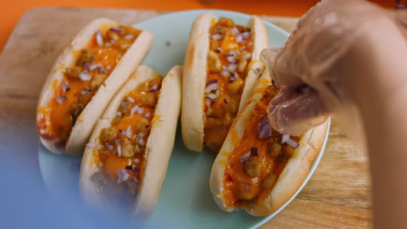 Press Red Onion Over Chili Cheese Hot Dogs