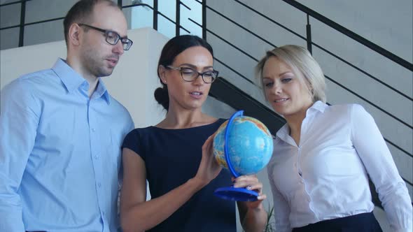 Three Teachers Discuss Something with Globe