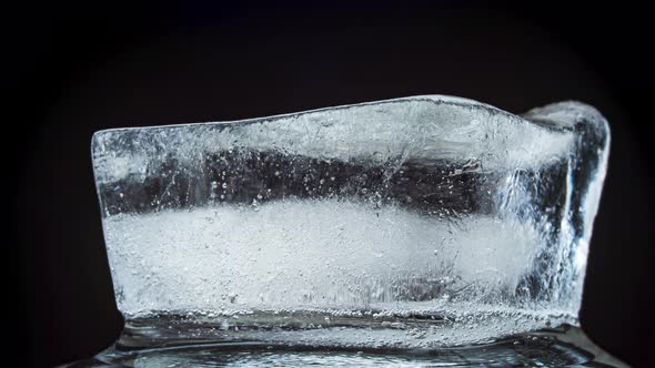 Ice Melts and Rotates on a Black Background