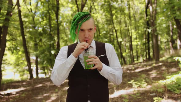 Young Man with Dreadlocks Drinking Refreshing Lemonade in Forest Park