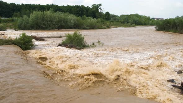 Wide dirty river with muddy water in flooding period during heavy rains in spring.