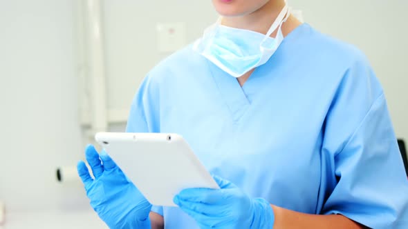 Female nurse using digital tablet in clinic