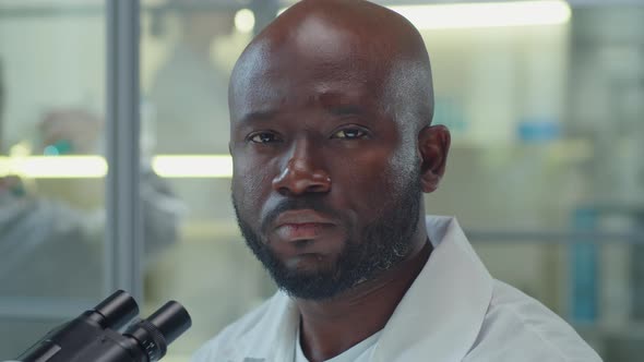 Portrait of African American Man with Microscope in Laboratory