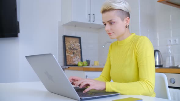 Freelancer woman typing on laptop computer at home during lockdown in 4k video