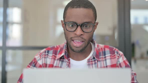 Close Up of African Man Celebrating Success on Laptop