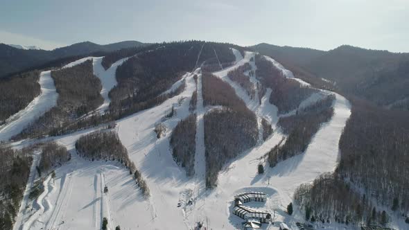 Aerial Panoramic Top View of the Ski Resort with Slopes Skiers and Snowboarders Moving Chairlifts