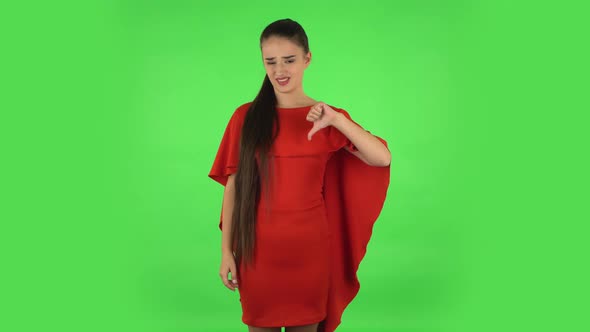 Pretty Young Unhappy Woman Is Showing Thumbs Down Gesture. Green Screen