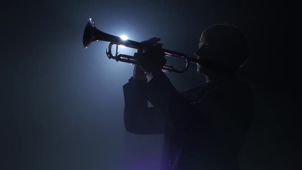 Trumpeter Plays a Wind Instrument Fast Melody. Studio in Smoke