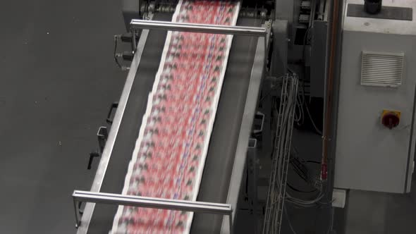 Newspapers at the conveyor belt of a printing factory