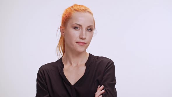 Middleaged Caucasian Female with Colored Orange Hair and Dark Brown Shirt Standing on White