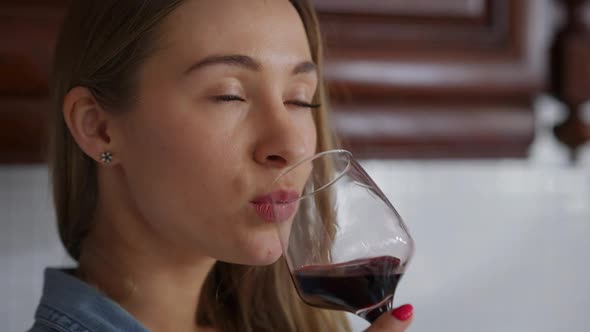 Closeup Portrait of Gorgeous Confident Young Caucasian Woman Smelling and Tasting Red Wine Smiling