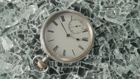 Top View of Silver Vintage Pocket Watch Lying on Shiny Crystals or Sparkling Glass Splinters