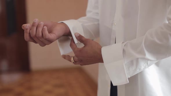 Handsome Groom Man Fixes His Cuffs on a Jacket with Cufflinks. Businessman