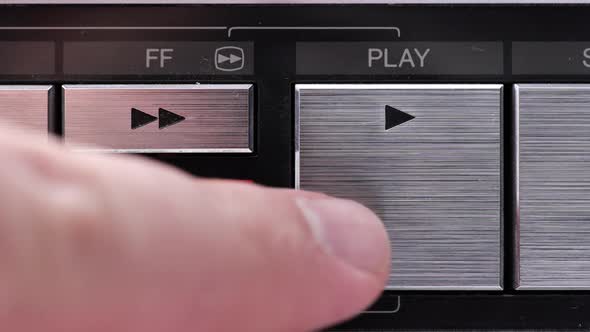 Extreme close up of buttons on an old antique or vintage VCR Pushing the Play button